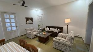 a living room with a couch and chairs and a table at Red Brick House in Panchkula