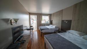 a hotel room with two beds and a television at Motel Giffard in Quebec City