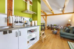 a kitchen with white cabinets and green walls at Beim Senner in Halblech +10 photos