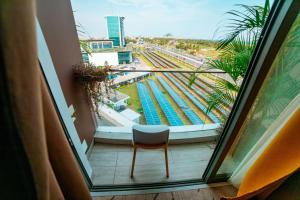 Ein Stuhl auf einem Balkon mit Blick auf einen Pool in der Unterkunft Bio Hôtel in Lomé