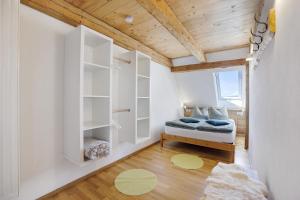 a bedroom with white walls and a wooden ceiling at Beim Senner in Halblech