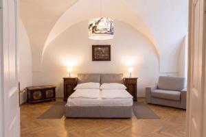 a bedroom with a bed and a chair at Three Golden Crowns Apartments in Prague
