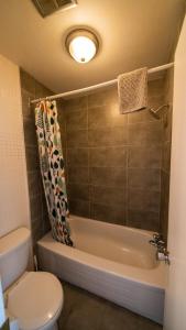 a bathroom with a toilet and a tub and a shower at Motel Giffard in Quebec City