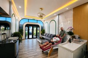 a man and woman sitting on a couch in a living room at Happy Life Hotel DaLat in Da Lat
