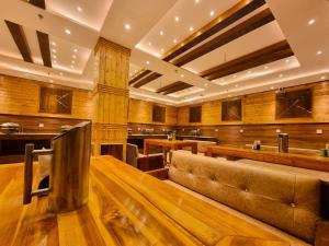a large room with a couch and a bar at Hotel Mistwood in Banikhet