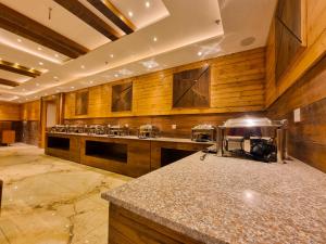 a large kitchen with wooden walls and a counter top at Hotel Mistwood in Banikhet +24 photos