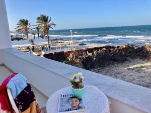 a table with a book and a magazine on a balcony with the beach at Waterside in Hammam Sousse