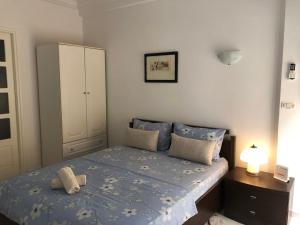 a bedroom with a bed with blue sheets and a cabinet at Waterside in Hammam Sousse