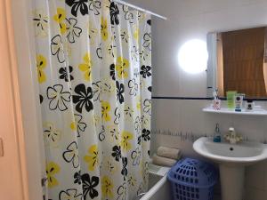 a bathroom with a sink and a shower curtain with flowers at Waterside in Hammam Sousse +22 photos