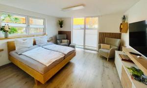 a bedroom with a bed and a couch and a tv at Apartment im Weinparadies in Weigenheim