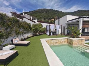 a backyard with a swimming pool and green grass at Villa Sueños in Mijas