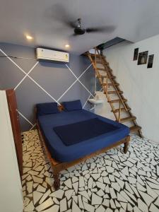 a bedroom with a blue bed in a room at Search hurt stays in Kuilapayam