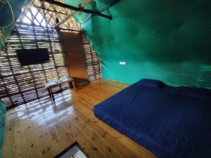 a bedroom with a blue bed and a wooden floor at Search hurt stays in Kuilapayam