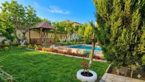 a backyard with a swimming pool and a gazebo at Green Garden Shuvelan in Baku
