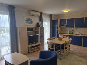 a kitchen and dining room with a table and blue cabinets at Adriatic Apartment in Skiper Resort in Savudrija
