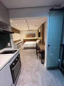 a kitchen and a bedroom with a bed in a room at Apartamento Studio in Arujá