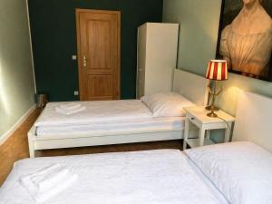 a room with two beds and a table with a lamp at Zentrale Ferienwohnung am Bad Muskauer Park 2 Schlafzimmer Parkplatz Top Lage in Bad Muskau