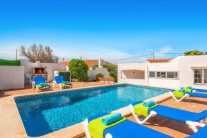 a swimming pool with chaise lounge chairs and a house at Villa San Jose by Villa Plus in Cala en Porter