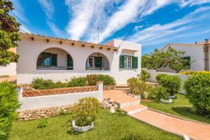 a house with a garden in front of it at Villa San Jose by Villa Plus in Cala en Porter