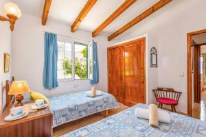 a bedroom with two beds and a window at Villa San Jose by Villa Plus in Cala en Porter