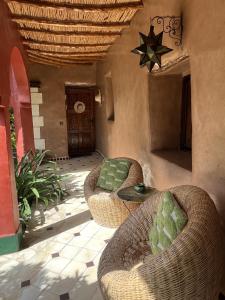 a patio with wicker chairs and a table and a star at Riad Beldi by MaHa in Oulad Teïma