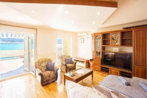 a living room with a couch and a tv at Apartments Galinec in Metajna