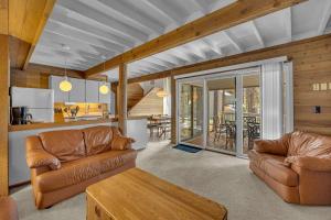 a living room with two leather couches and a kitchen at Pine Mountain - Unit 13 in Sunriver