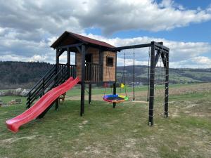 a playground with a slide and a play structure at Domek Pod-Górski in Baligród