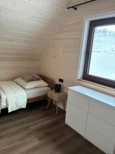 a small bedroom with a bed and a window at Domek Pod-Górski in Baligród