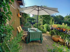 a patio with a table and an umbrella at Freilandhof in Ötisheim