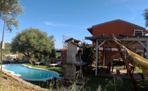 ein Garten mit Pool und Pavillon in der Unterkunft Su Kiniperu in Maracalagonis