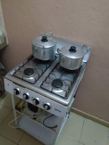 two pots and pans sitting on top of a stove at Résidence BEDEL in Yamoussoukro +37 photos