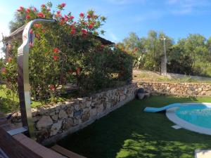 ein Garten mit Stützmauer und Swimmingpool in der Unterkunft Su Kiniperu in Maracalagonis + 38 Fotos