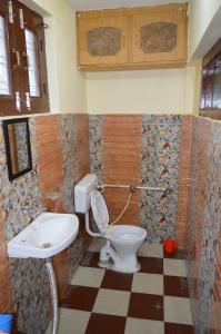 a bathroom with a toilet and a sink at Yatra Homestay in Joshīmath