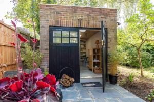 a small brick house with a black door at The Nook Guest House in Letchworth