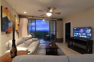 a living room with a couch and a flat screen tv at Stunning Oceanview Condo with Exceptional Views & Resort-Style Amenities in Coco +29 photos