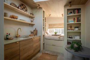a kitchen with wooden cabinets and a sink and a window at The Nook Guest House in Letchworth