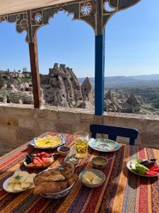a table with plates of food on it with a view at Dancing Cloud Art House in Uçhisar
