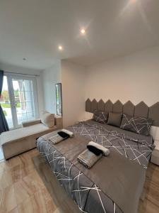 a large bedroom with a large bed and a couch at Villa Dimo Topal Luxury Suites with Pool & Jacuzzi in Ohrid