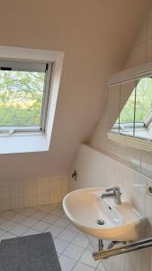 a bathroom with a sink and two windows at Apartment Kist bei Würzburg in Kist