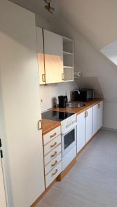 a small kitchen with white cabinets and a sink at Apartment Kist bei Würzburg in Kist