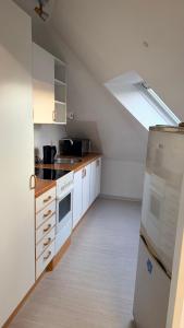 a kitchen with white cabinets and a refrigerator at Apartment Kist bei Würzburg in Kist