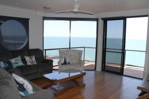 un soggiorno con un divano e un tavolo di Sunset Sails Penthouse Redcliffe a Redcliffe
