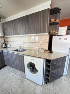 a kitchen with a washing machine and a sink at Patagonia y Deloqui in Ushuaia +5 photos