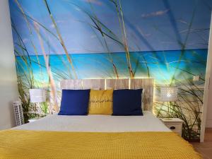 a bedroom with a bed with blue and yellow pillows at Thelighthouse Porto Santo in Porto Santo