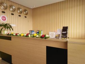 un bancone della reception con fiori sopra di Amigo Hotel a Seri Iskandar