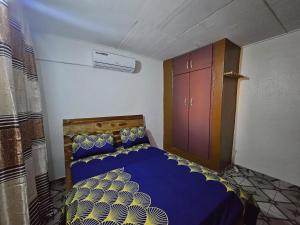 a bedroom with a bed and a cabinet in it at Résidence BEDEL in Yamoussoukro