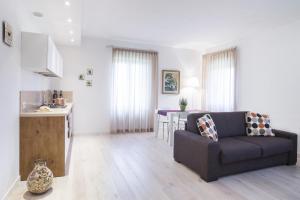 a living room with a couch and a kitchen at Country Resort Canova in Negrar