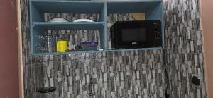 a bathroom with a tv on a tiled wall at Résidence BEDEL in Yamoussoukro