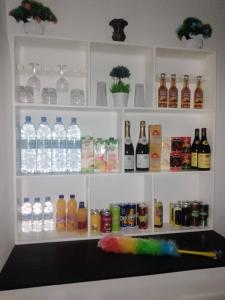 a shelf filled with bottles of water and alcohol at Résidence BEDEL in Yamoussoukro